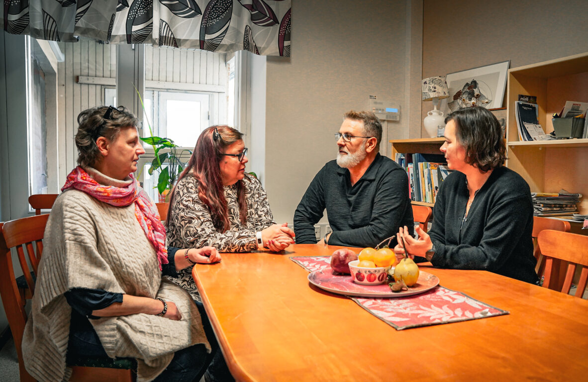 Invandrartjänsternas team sitter kring ett bord och diskuterar